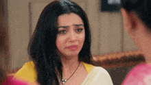 a woman is crying while sitting next to another woman .