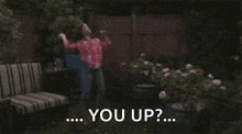 a girl in a red plaid shirt is standing in front of a blue barrel .