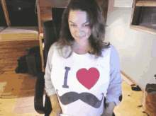 a woman is wearing a shirt that says i heart mustaches