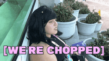 a woman sitting in front of potted plants with the words we 're chopped below her