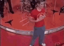 a group of people dancing on a red carpet in a room .