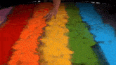 a person is standing on a trampoline with a rainbow of colors painted on it .