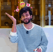 a man with a beard is wearing a striped shirt with hearts coming out of it