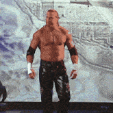 a man without a shirt is standing in front of a large screen with a star in the middle