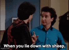 two men are standing next to each other and one of them is saying when you lie down with sheep .