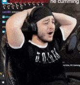 a man wearing headphones and a bandana is sitting in a chair with his hands behind his head .