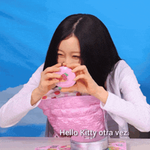 a girl is holding a pink hello kitty toy