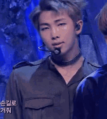 a close up of a man wearing a microphone and a choker .