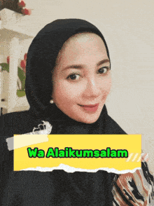 a woman wearing a black hijab and a yellow sign that says wa alaikussalam