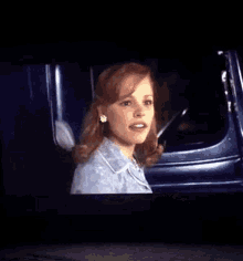 a woman is sitting in a car and smiling