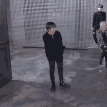 a man is dancing in front of a wall with korean writing