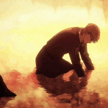 a man in a suit is kneeling in a body of water with a sunset in the background