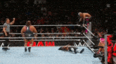 a wrestler is jumping over another wrestler in a wrestling ring while a referee watches .