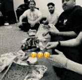 a black and white photo of a group of people sitting around a bag of doritos chips