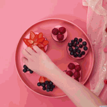 a pink plate with strawberries blueberries and hearts on it