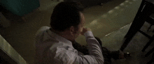 a man is reaching out his hand towards another man .