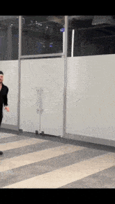 a man is standing in front of a glass door with a sign that says ' exit ' on it