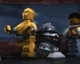 a lego r2d2 robot is chained to a c3po robot