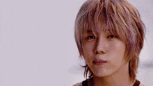 a young man with blonde hair is looking at the camera
