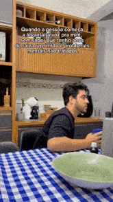 a man sits at a table with a laptop and a cup of coffee with a caption that says quando a pessoa começa