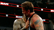 two wrestlers are standing in front of a raw banner