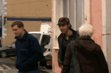 a man in a baseball cap talks to a woman in a purple jacket