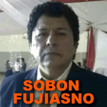 a man in a suit and tie with the words " sobon fujiasno " behind him
