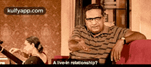 a man sitting on a couch with the words " a live-in relationship " on the bottom
