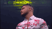 a man wearing a floral shirt and sunglasses is standing in front of a green background .