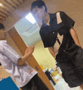 two men are standing next to each other in a room and one of them is pointing at the other