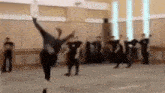 a group of people are dancing in a room with a blurred background .
