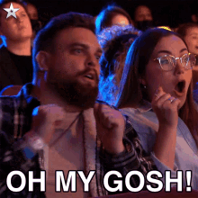 a man and a woman are sitting in a theater with the words oh my gosh on the screen