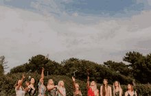 a group of women are standing in a line throwing confetti into the air