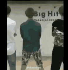 a group of men are standing next to each other in front of a big hit entertainment sign .