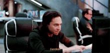 a man in a black shirt is typing on a keyboard and says eureka