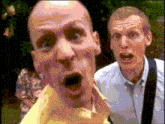 a man in a yellow shirt is making a surprised face next to another man