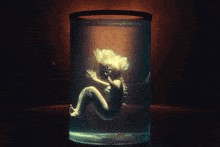 a person is sitting in a glass container of water
