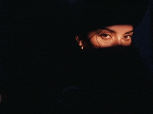 a close up of a woman 's face with a light shining on it