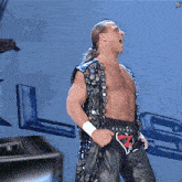 a shirtless wrestler is standing in front of a sign that says lg