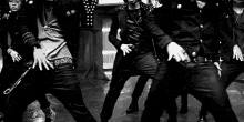 a black and white photo of a group of men dancing in the rain .