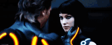 a man and a woman are looking at each other and the woman has a glowing glove on