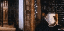 a woman is sitting in a chair in a dark room with a teapot in her hand .