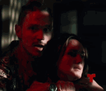 a man is pointing at a woman with a red r on the bottom right