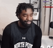 a man with a beard is wearing a black north point jersey