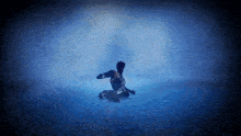 a silhouette of a person kneeling down in a dark room