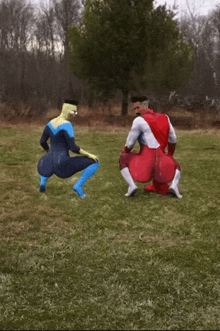 two superheros are squatting in a grassy field
