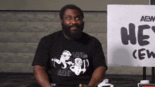 a man sitting in front of a sign that says aew crew