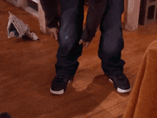 a person standing on a wood floor with a newspaper on the floor