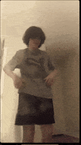 a young man wearing a puma shirt and shorts is standing in a room
