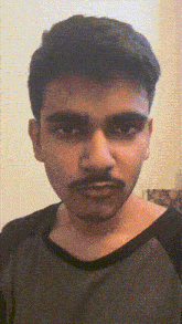 a man with a mustache is wearing a black and green shirt